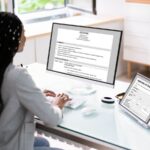 person at computer typing up a resume